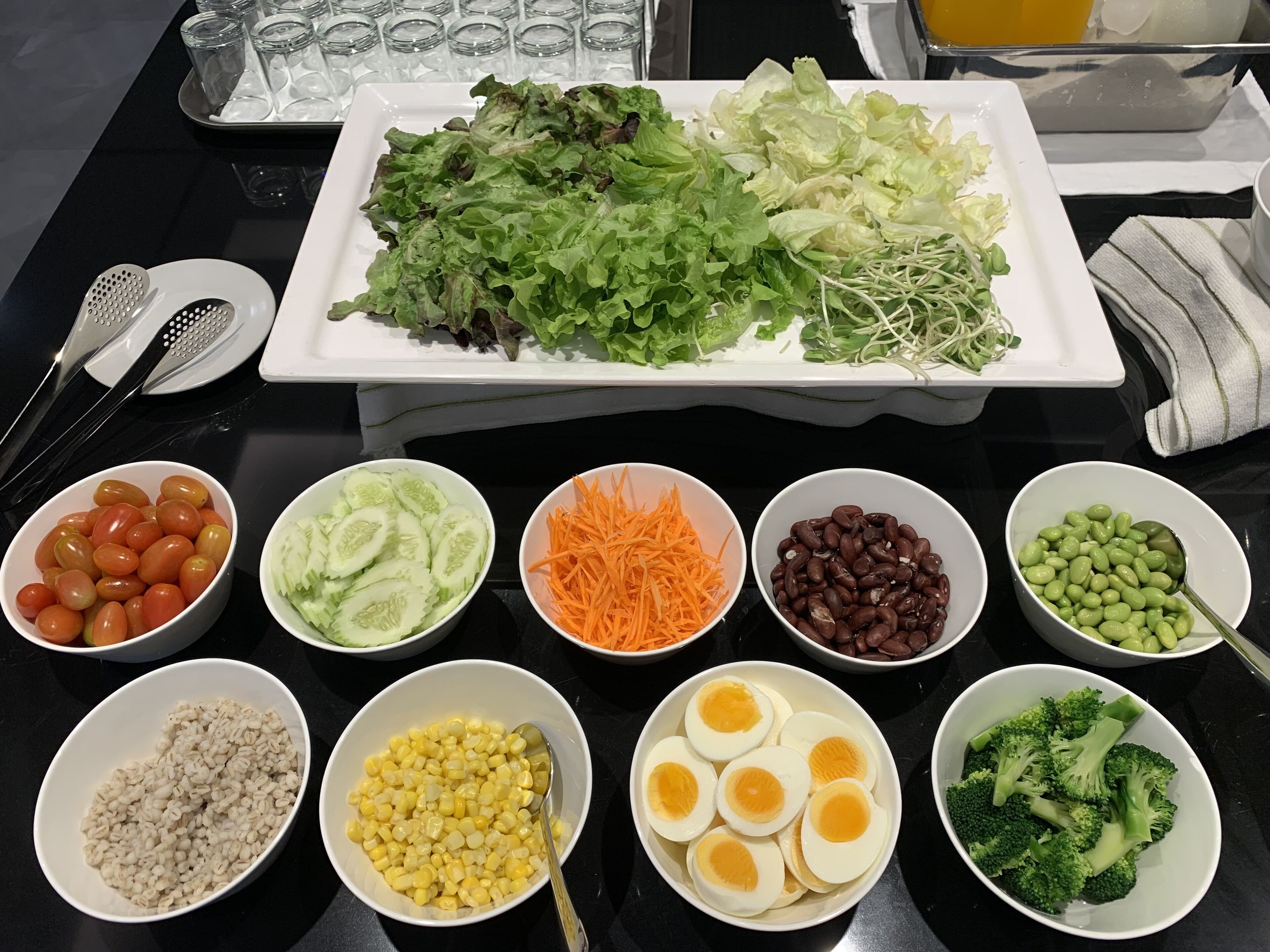 A table with various food items including vegetables, beans, and rice.