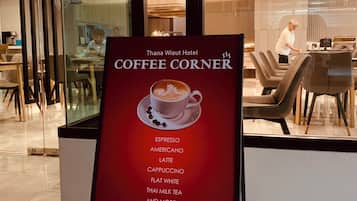 A hotel interior with a coffee corner sign listing various coffee types.