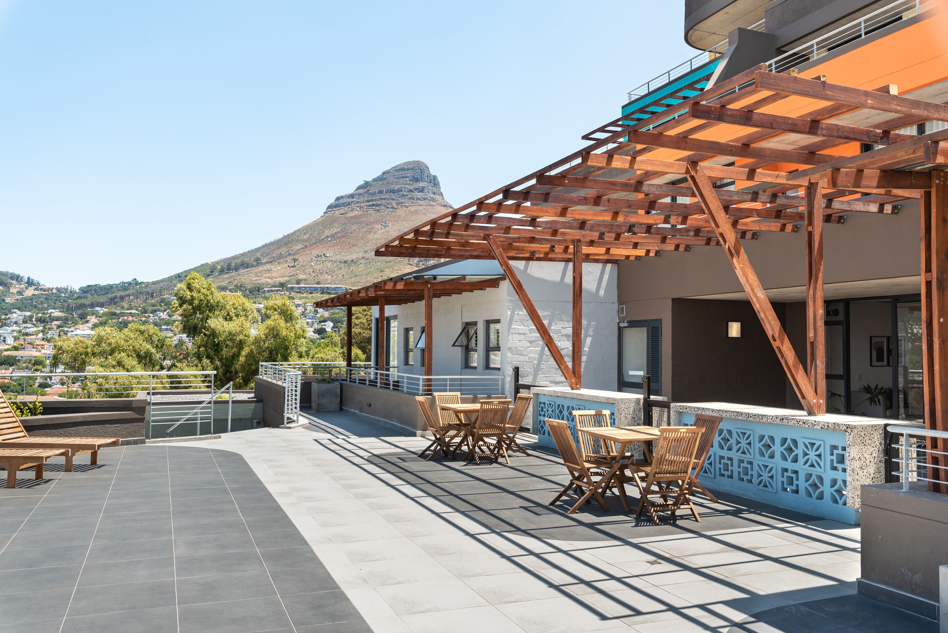 Una terraza al aire libre con muebles de madera y vistas a la montaña.