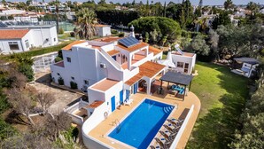 Una villa moderna con piscina, paneles solares y un jardín bien cuidado.
