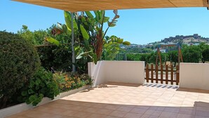 Um alpendre coberto com vista para uma colina e um castelo.
