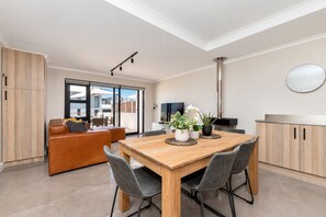 A modern kitchen with a wooden table, chairs, and a built-in stove.