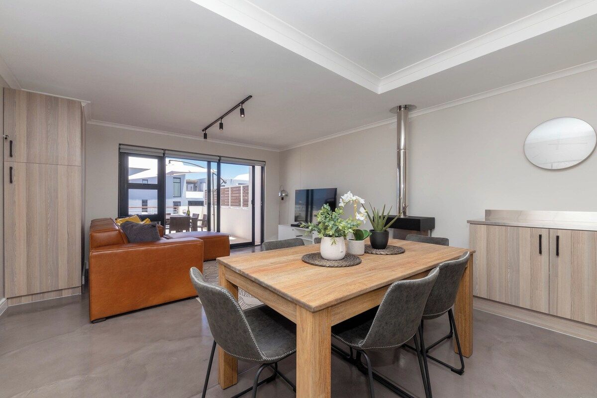 Ein modernes Interieur mit Essbereich, einer Couch und einer Küche.
