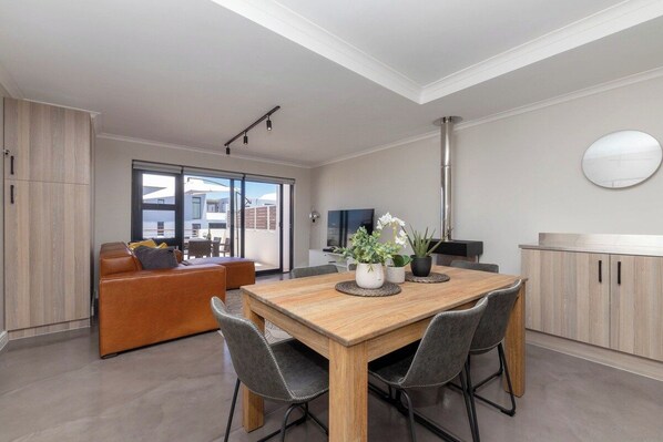A modern interior with a dining area, a sofa, and a kitchen.