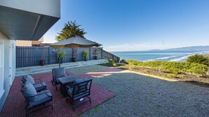 Un patio con mobili da esterno e vista sull'oceano.