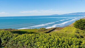 Paesaggio costiero con vista chiara sull'oceano e una zona erbosa in primo piano.