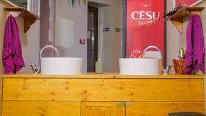 A wooden vanity with two sinks, a mirror, and a trash bin. - Cinnamon Sally Backpackers Hostel (Riga)