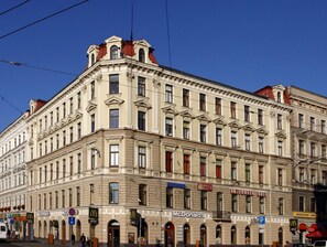 Il s’agit d’un bâtiment historique dont le rez-de-chaussée abrite plusieurs restaurants McDonald’s. Il se distingue par son architecture classique, avec ses fenêtres en arc et sa façade symétrique.