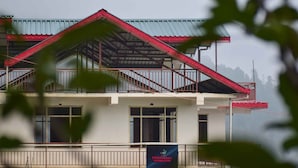 Een gebouw met een rood dak en een banner met daarop 'Cairndon Homestay'.