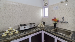 Een keuken met een marmeren aanrecht, een roestvrijstalen spoelbak en een raam met een decoratieve spiegel.