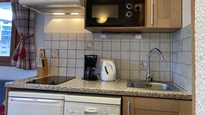 Una cocina equipada con microondas, cafetera y lavavajillas.