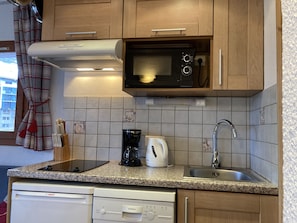 A kitchen with a microwave, coffee maker, and dishwasher.