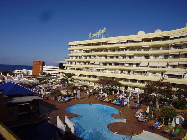 A hotel with a pool area, multiple balconies, and a view of the ocean. - 1 Bedroom Apartment With Air Conditioning & Free WIFI Pool & Sea View (Costa Adeje)