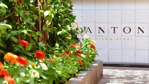 Un jardín con un muro de azulejos que muestra los nombres ANTON y VIAGGIATORI.