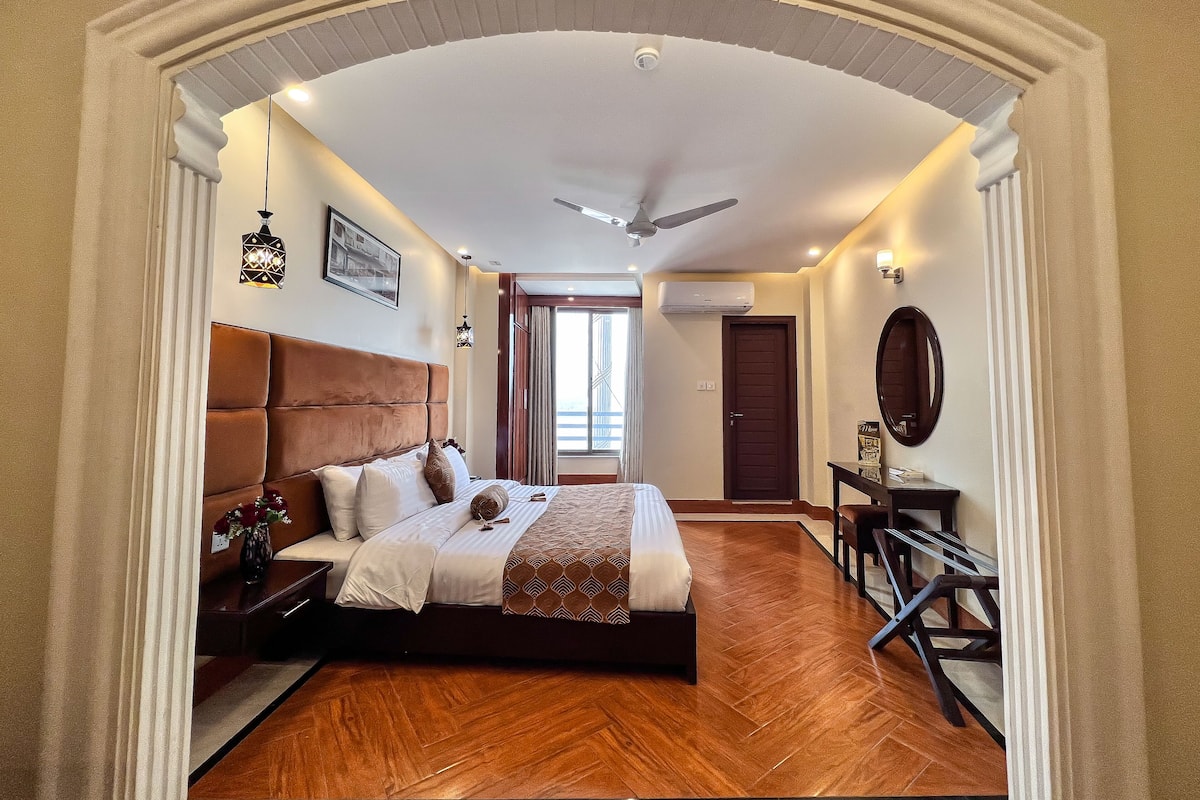 Un dormitorio con una cama grande, ventilador de techo y vistas al exterior.
