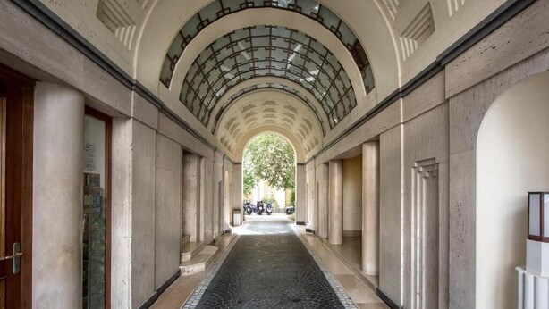 A corridor with a tiled floor, columns, and a glass ceiling. - AD MAIORA Boutique Suite (Naples)