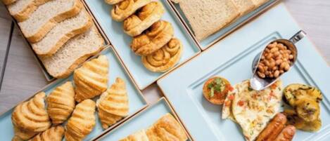 A variety of pastries and bread on plates.