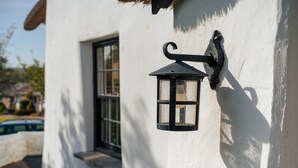 Een wit gebouw met een zwarte lantaarn aan de muur.