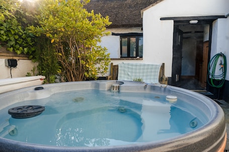 Outdoor spa tub. Poyers Thatched Farmhouse with Hot Tub
