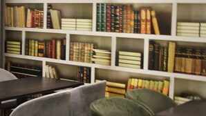 Une bibliothèque avec des étagères remplies de livres, une table et deux chaises.