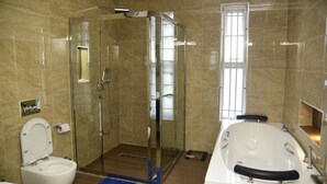 Un baño con ducha de vidrio, bañera y un inodoro.