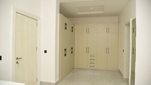 Un pasillo con un armario beige, una puerta con llave y suelo de baldosas.