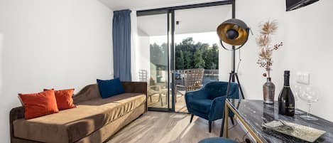 Een moderne woonkamer met een bank, stoelen, een tafel en een groot raam.