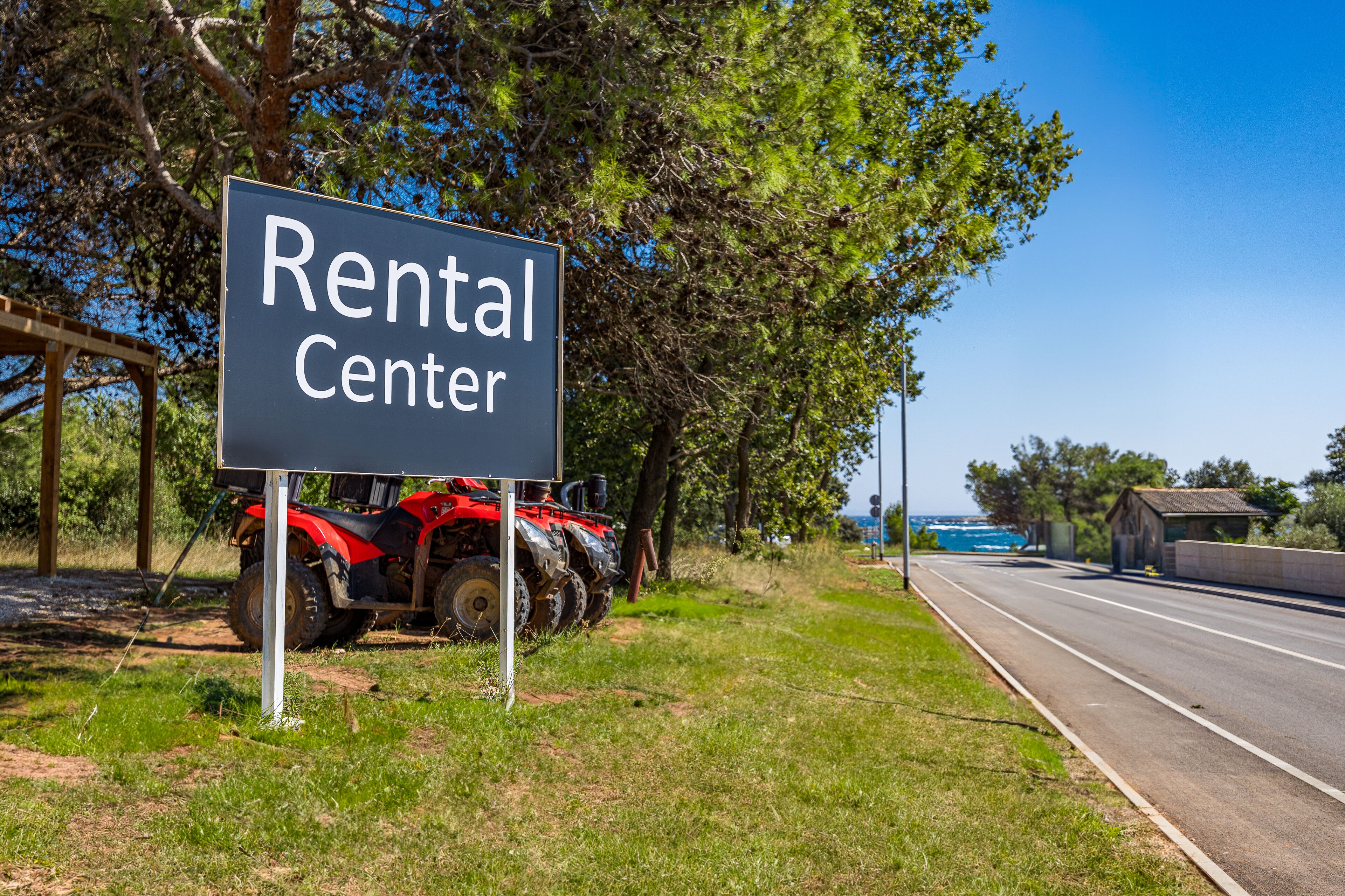 Schild mit der Aufschrift 'Rental Center', in der Nähe ein roter ATV.