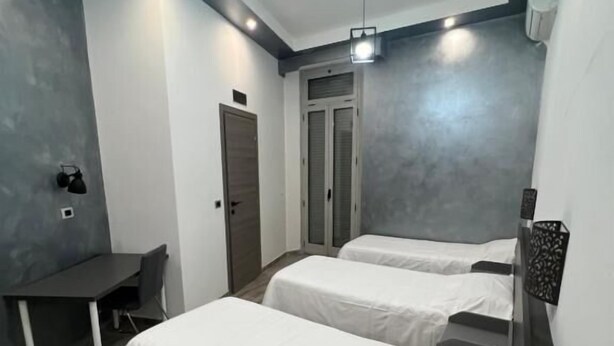 Une chambre d’hôtel moderne avec deux lits, un bureau et une chaise.
