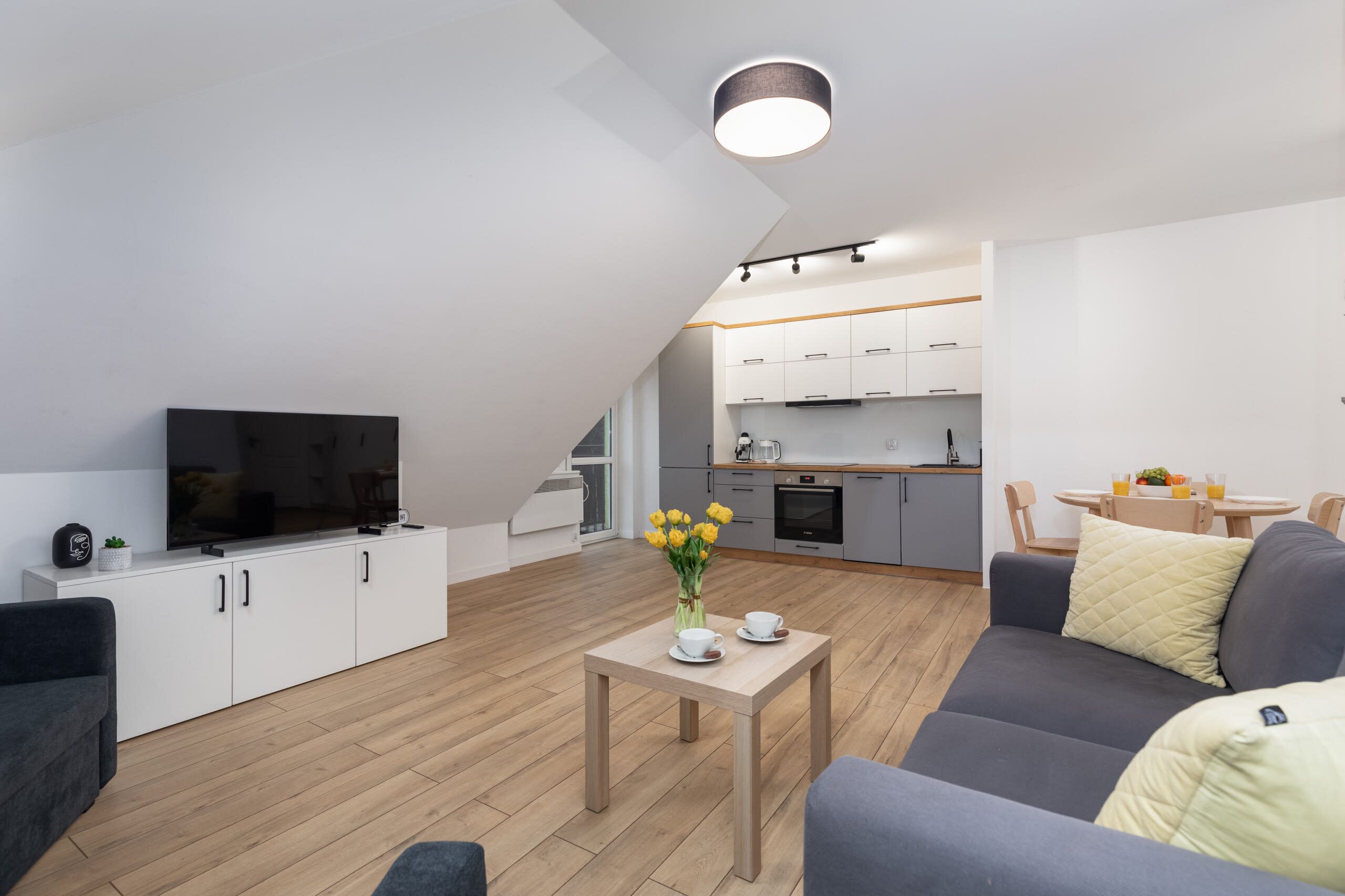 Een modern appartement met een woonkamer, keuken en een eethoek.