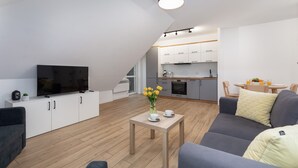 Ein modernes Apartment mit Wohnzimmer, Küche und Essbereich.