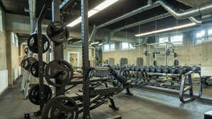 Ein Fitnessstudio mit Gewichthebern, Laufbändern und Kurzhanteln.