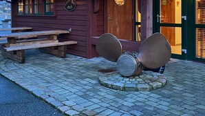 A wooden building with a red-tiled roof, a wooden door, and a sign that reads "Country Bar". - Sirevåg Hotel (Ha)
