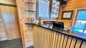 A wooden reception desk with a black countertop, a map on the wall, and a framed certificate. - Sirevåg Hotel (Ha)