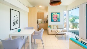 Un salon moderne avec un coin repas, un canapé et une cuisine en arrière-plan.