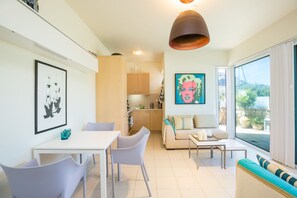 Un salon moderne avec un coin repas, un canapé et une cuisine en arrière-plan.