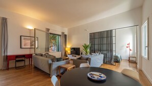 Ein modernes Wohnzimmer mit einer Couch, einem Esstisch und einem Fernseher.