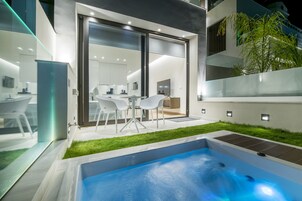 Un área de piscina moderna al aire libre con un porche acristalado y un conjunto de comedor.
