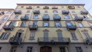 A multi-story building with balconies, a wooden door, and a no parking sign. - Casa del Monumento del Re by Wonderful Italy (Torino)