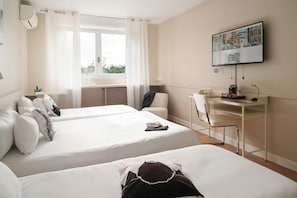 A hotel room with two beds, a desk, a chair, a television, and a window with curtains. - Logis Hotel Thermal (Saubusse)