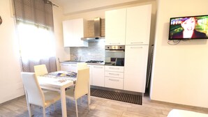 Eine moderne Küche mit weißen Schränken, einem Gasherd und einem Backofen.