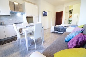 A modern apartment with a kitchen, dining area, and living room.