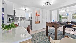 A modern kitchen with white cabinets, a marble countertop, and a ceiling fan. - Villa Bonita | 6BR | Pool + Hot Tub (Miami)