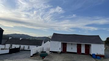A building with a white exterior, red doors, and a gravel driveway.