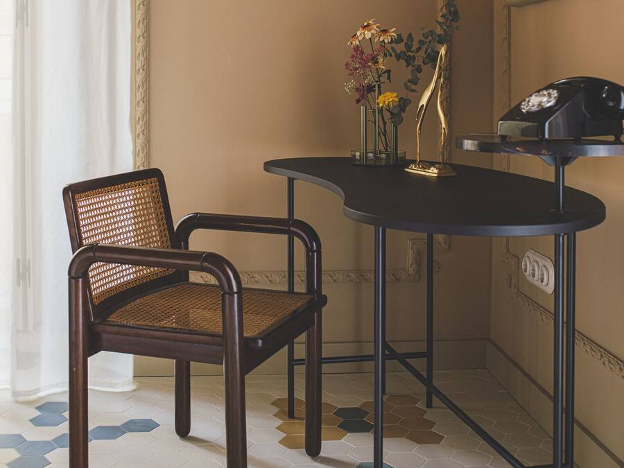 Une pièce d’angle avec une chaise, une petite table et un téléphone.