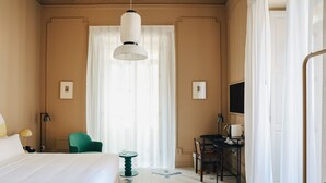 Ein Hotelzimmer mit Bett, Schreibtisch, Stuhl und Fernseher.