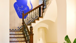 Eine Treppe mit aufwendiger Geländerarbeiten und einem gemusterten Boden.