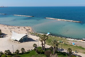 A beach with a modern structure, clear blue water, and a rocky breakwater. - Apartment 'La Dimora Sul Mare' with Sea View, Wi-Fi and Air Conditioning (Bari)