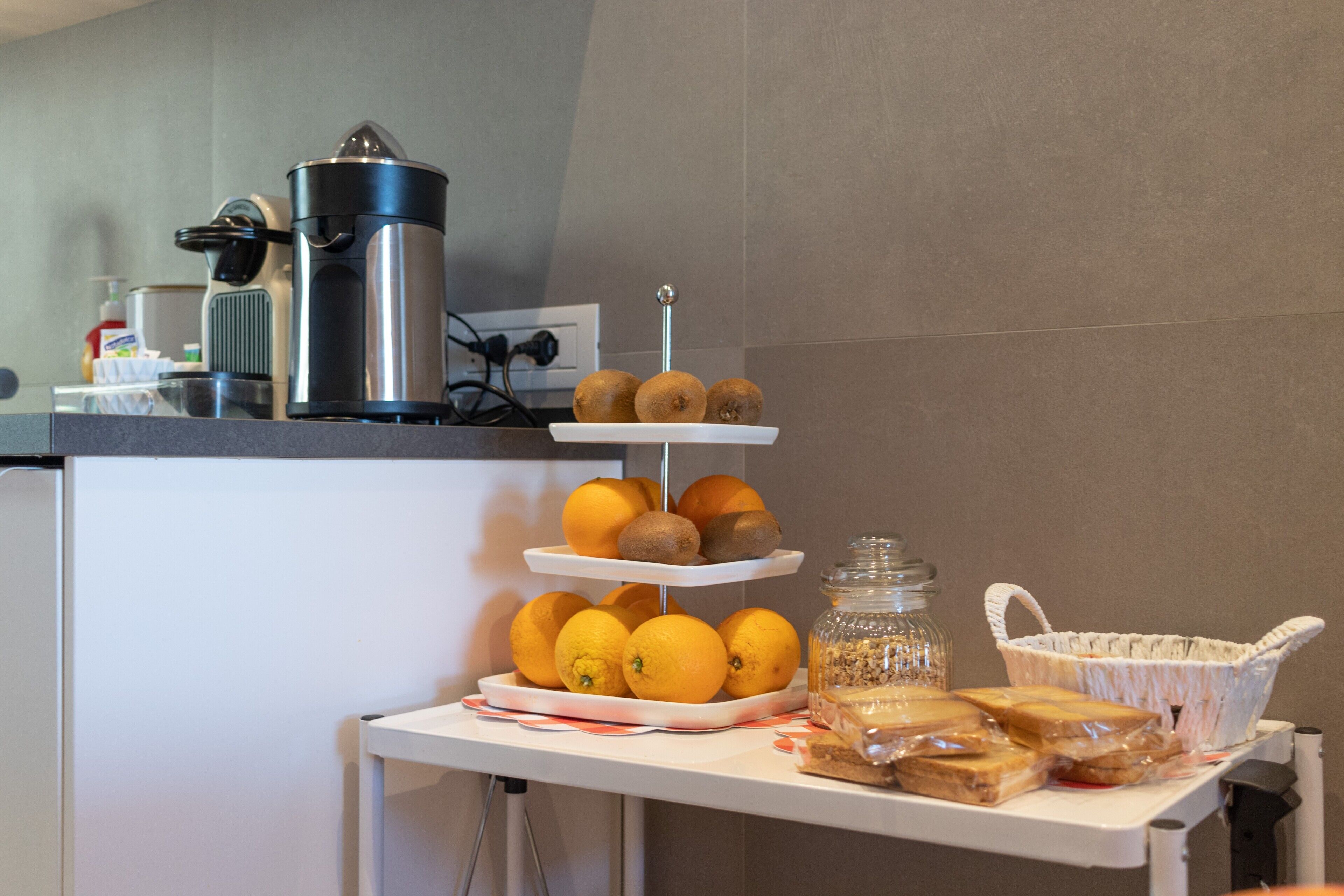 Un buffet per la colazione con arance, kiwi e pane su un tavolo.