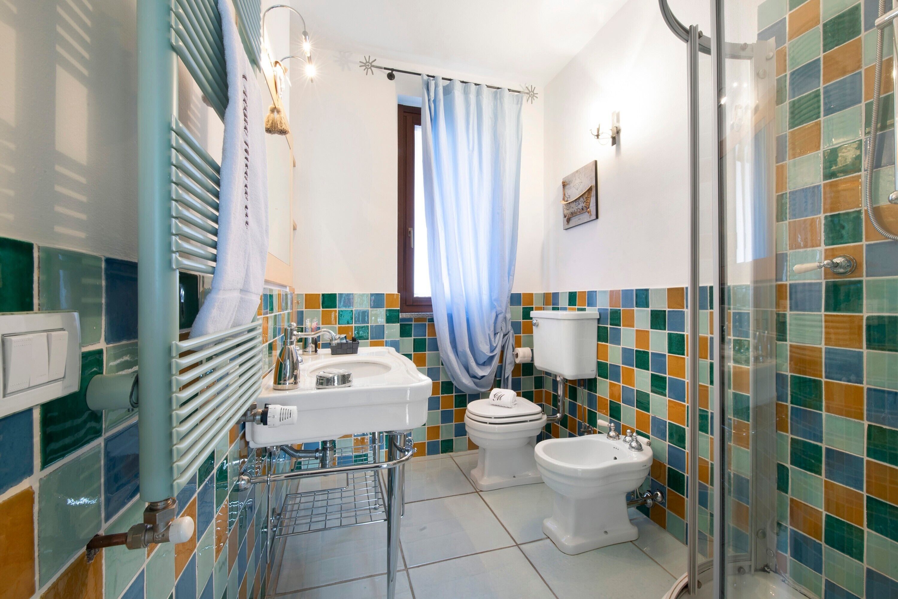 Ein Badezimmer mit Dusche, Toilette, Bidet und Waschbecken.